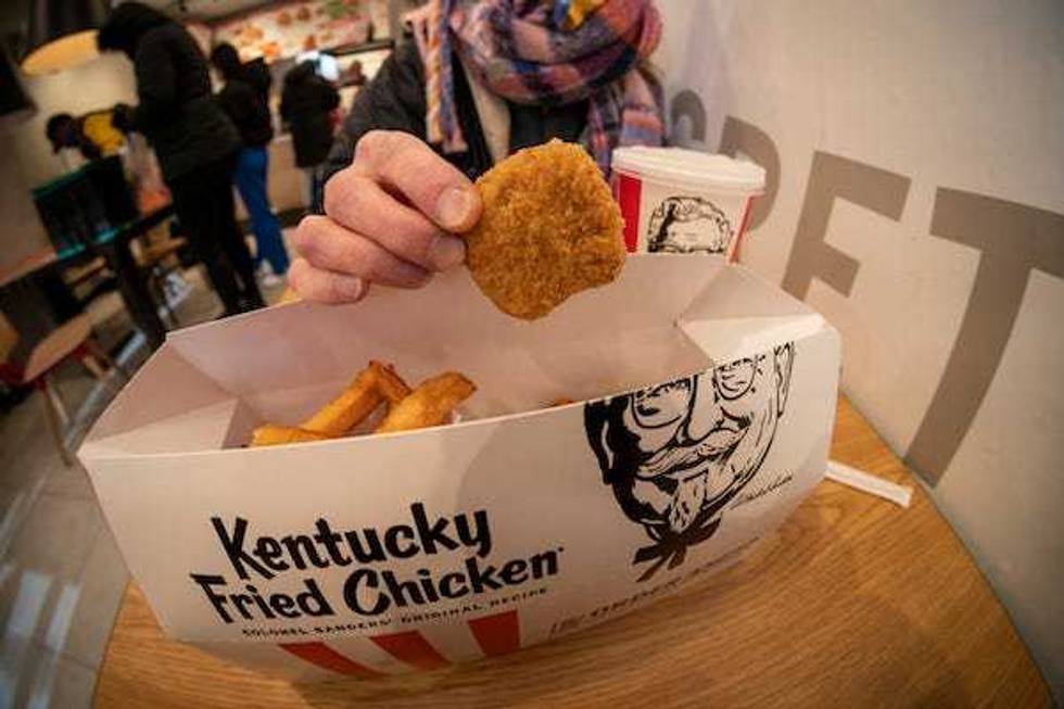 A woman enjoys a combo order of Beyond Fried Chicken at a KFC in Midtown Manhattan