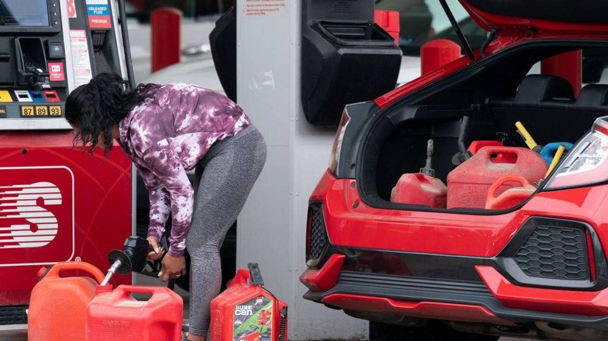 A woman fills gas cans at a Speedway gas station on May 12, 2021 in Benson, North Carolina. Most stations in the area along I-95 are without fuel following the Colonial Pipeline hack. The 5,500 mile long pipeline delivers a large percentage of fuel on the East Coast from Texas up to New York.