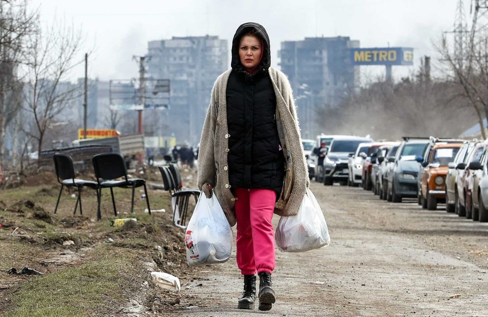 A woman follows a humanitarian corridor established for civilians in Mariupol on March 17, 2022