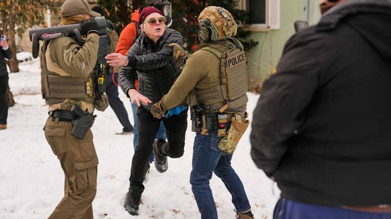 A woman gets into an altercation with a federal immigration officer as officers make an arrest Sunday, Jan. 11, 2026, in Minneapolis.