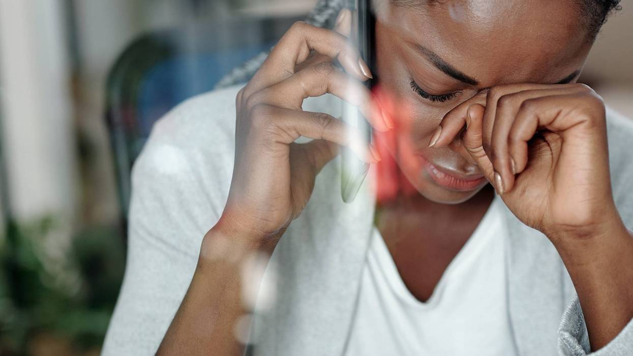 A woman grieving while talking on the phone.