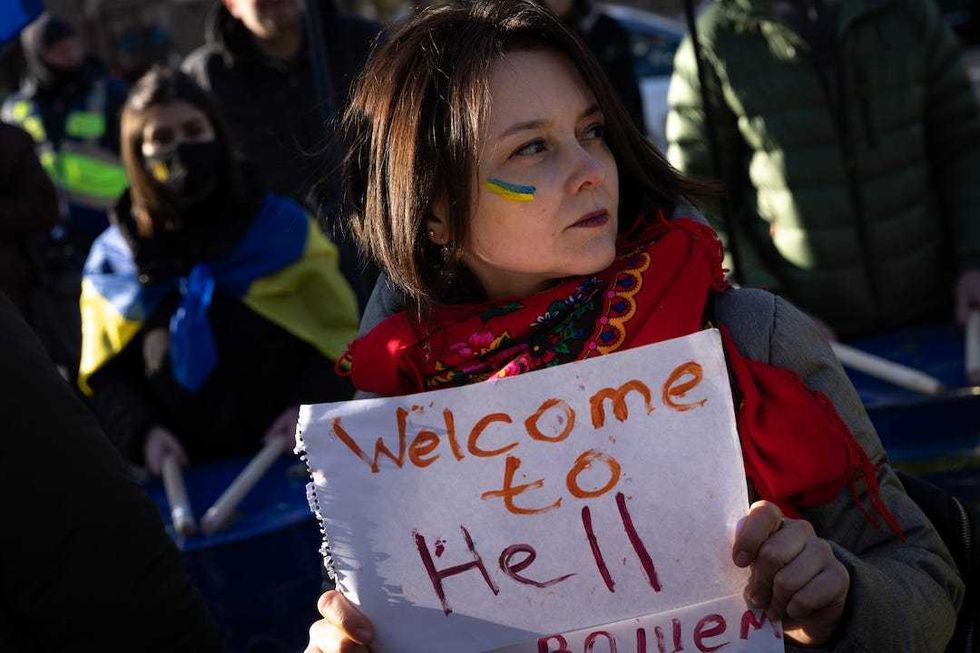 A woman holds a sign during a protest outside the Russian Embassy on February 22, 2022 in Kyiv, Ukraine