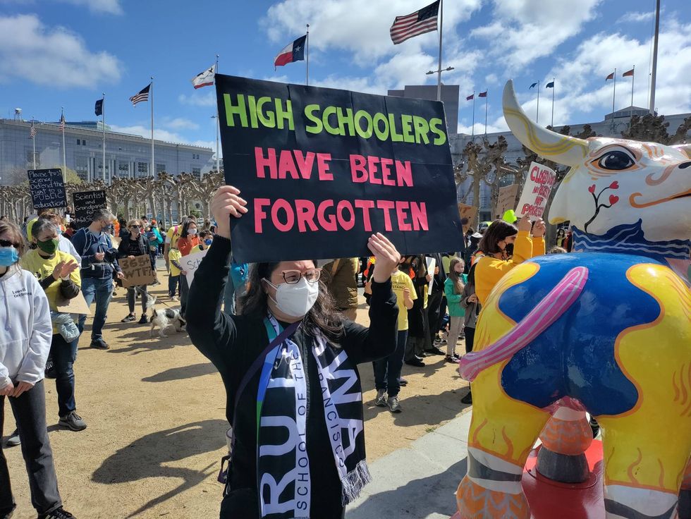 A woman holds up a sign to support the reopening of San Francisco