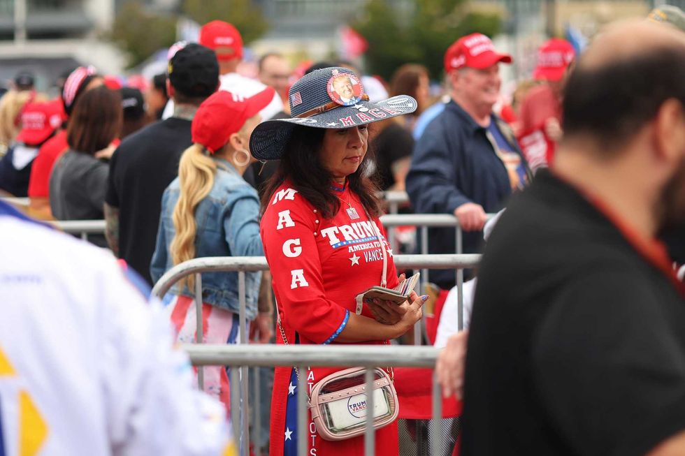 A woman in a "MAGA" hat waits outside Nassau Coliseum