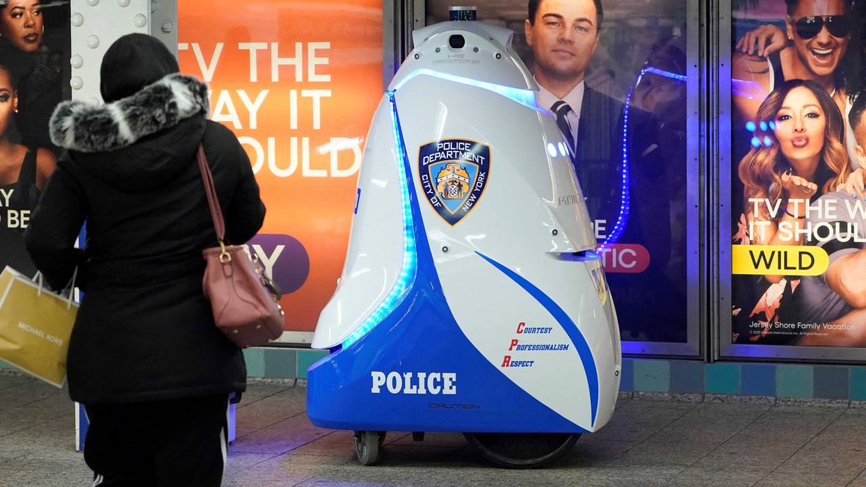A woman looks at the K5 robot used by the New York City Police Department (NYPD) in the Times Square subway station on Nov. 28, 2023