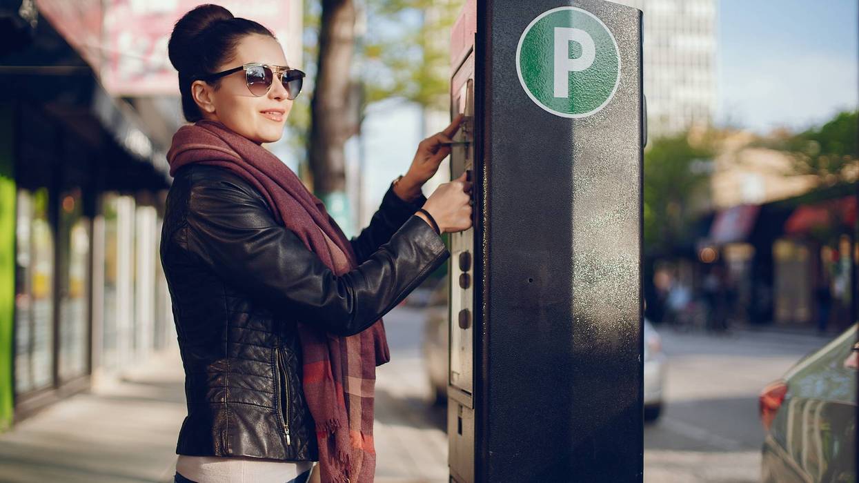 A woman pays for street parking in Chicago.