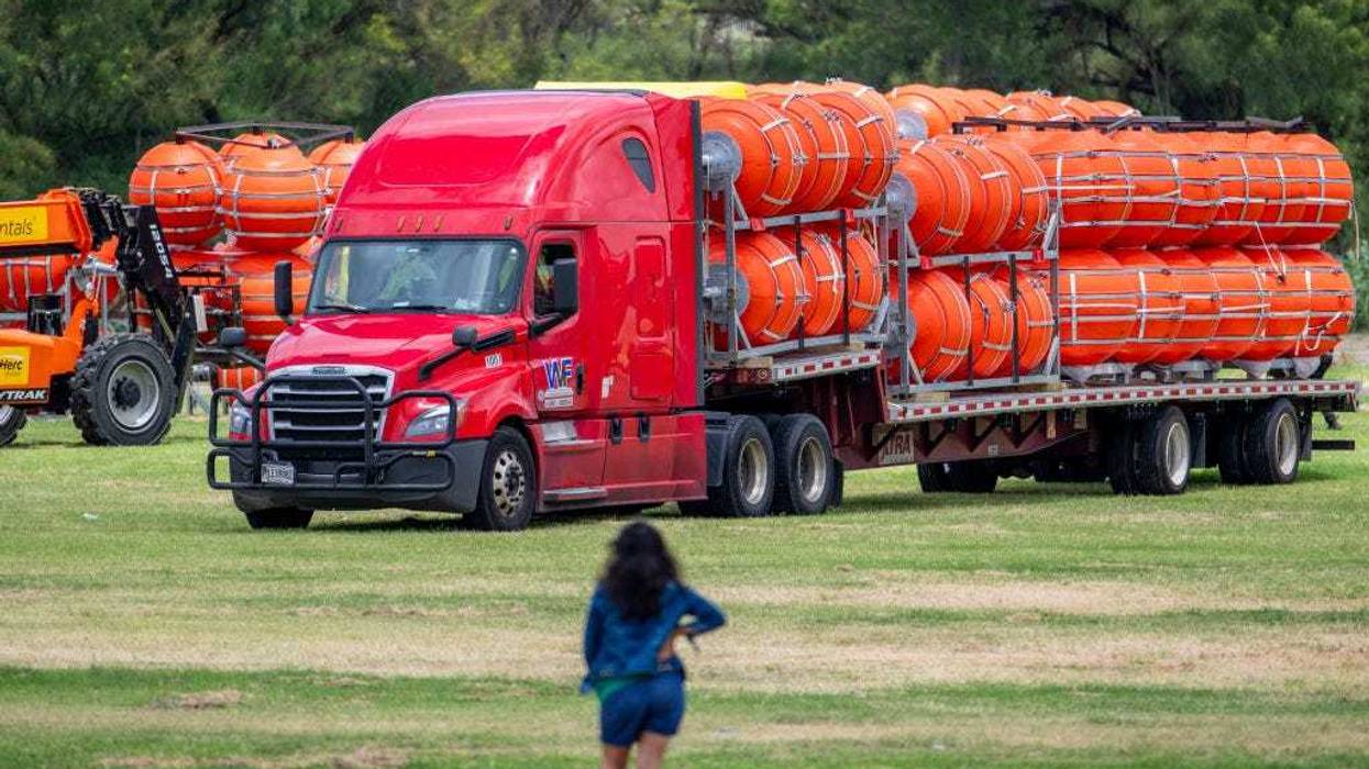 A woman surveys the preparation of a buoy barrier installation on July 07, 2023 in Eagle Pass, Texas.