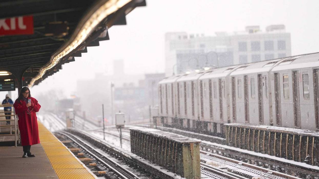 A woman waits at a subway station during snowfall on January 6, 2025
