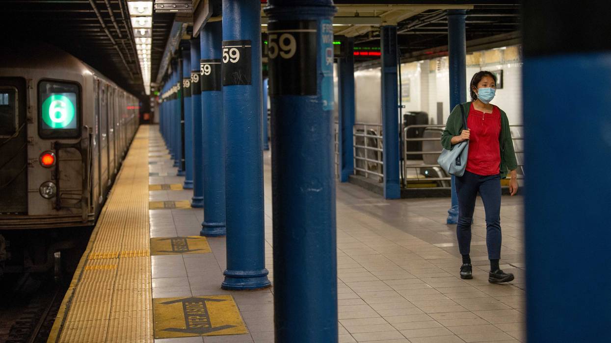 A woman walks on a platform at the Lexington Avenue/59th Street station