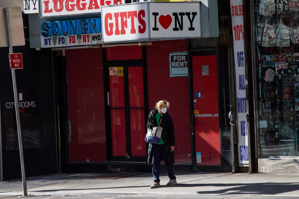 A woman walks past a shuttered souvenir store at Times Square on November 16, 2020 in New York.