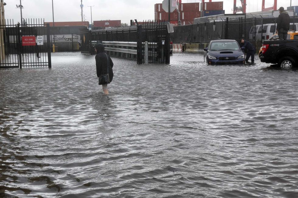 A woman walks through the flooded streets in the Red Hook neighborhood on September 29, 2023