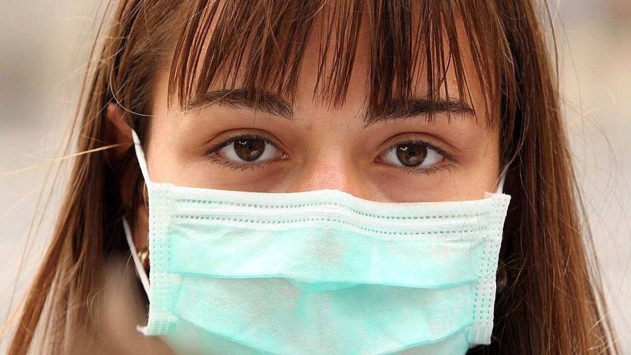 A woman wearing a surgical mask to prevent the transmission of airborne infection walks in Westminster on July 30, 2009 in London, England.