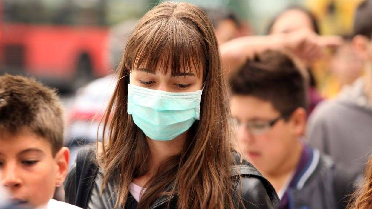 A woman wearing a surgical mask to prevent the transmission of airborne infection walks in Westminster on July 30, 2009 in London, England.