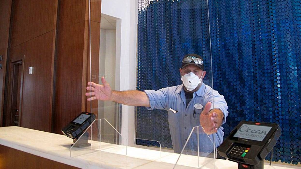 A worker at Ocean Casino Resort in Atlantic City, New Jersey, installs a protective panel at a check-in area on June 3, 2020, about a month before it reopened during the early days of the COVID-19 pandemic.