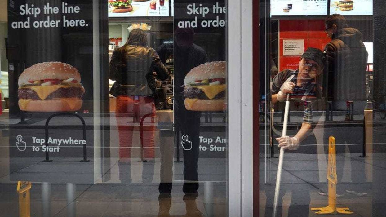 A worker cleans the floor in a McDonald's restaurant in the Chicago Loop on March 19, 2020 in Chicago, Illinois.