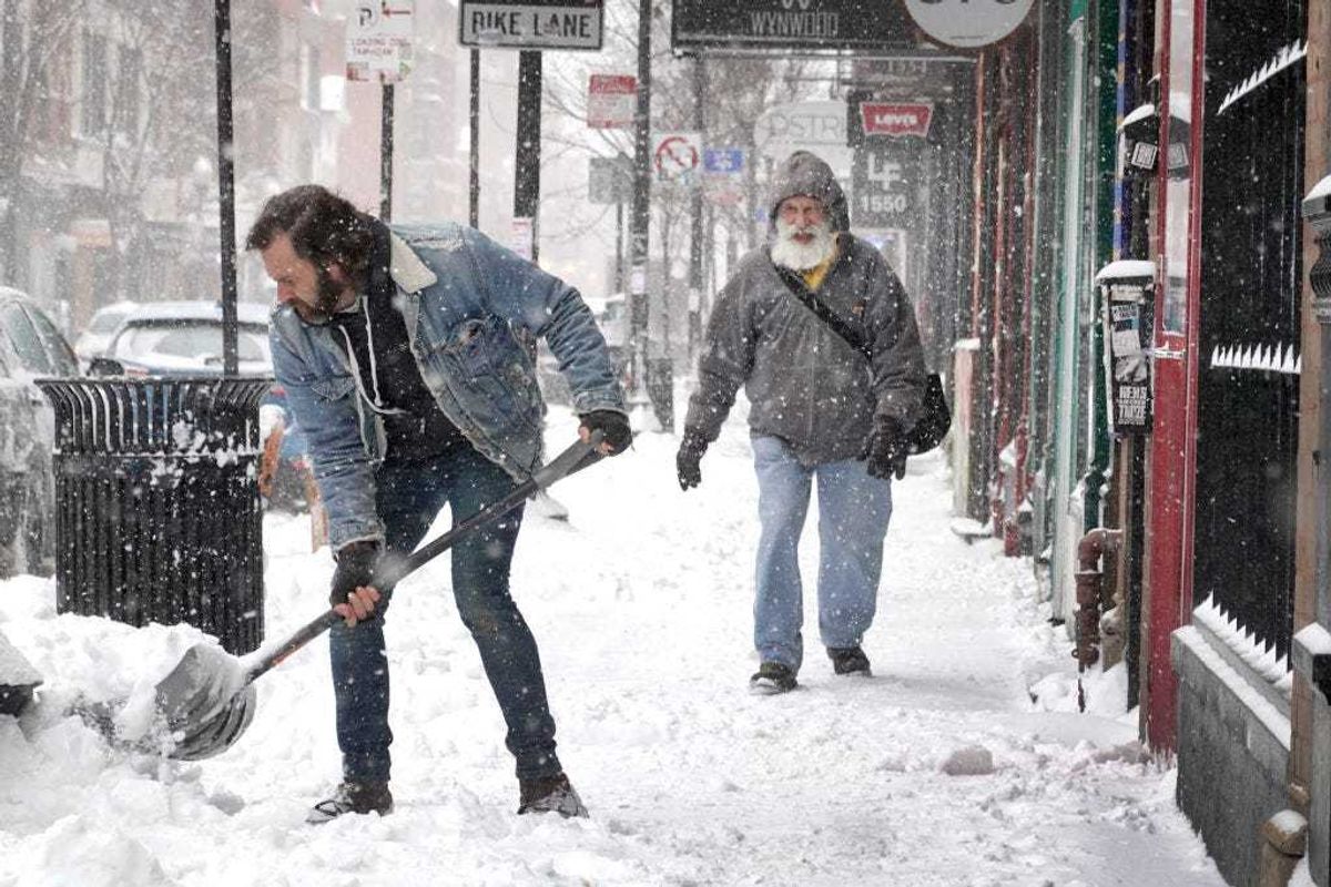 A worker clears snow from the front of a business on February 02, 2022 in Chicago, Illinois. A massive storm, working its way across the Midwest, is expected to dump as much as 16 inches of snow in some areas. Chicago is expected to receive between 4 and 8 inches by the time the system passes tomorrow afternoon. (Photo by Scott Olson/Getty Images)