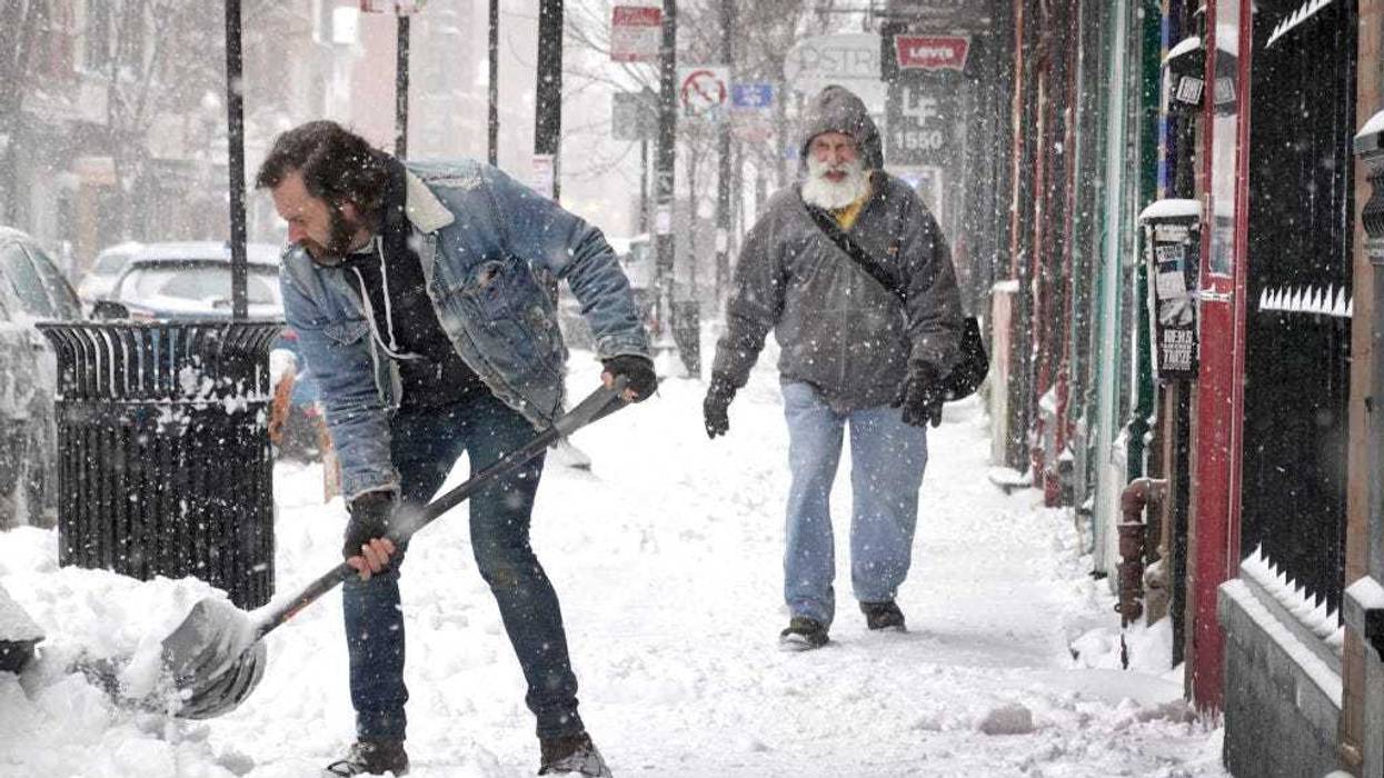 A worker clears snow from the front of a business on February 02, 2022 in Chicago, Illinois. A massive storm, working its way across the Midwest, is expected to dump as much as 16 inches of snow in some areas. Chicago is expected to receive between 4 and 8 inches by the time the system passes tomorrow afternoon. (Photo by Scott Olson/Getty Images)