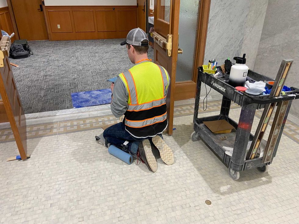 A worker freshens up some of the new finishes in the mayor