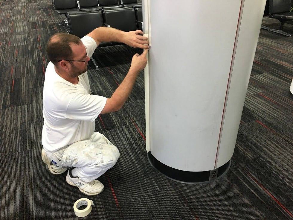 A worker in 2016 repaints parts of Lambert Airport