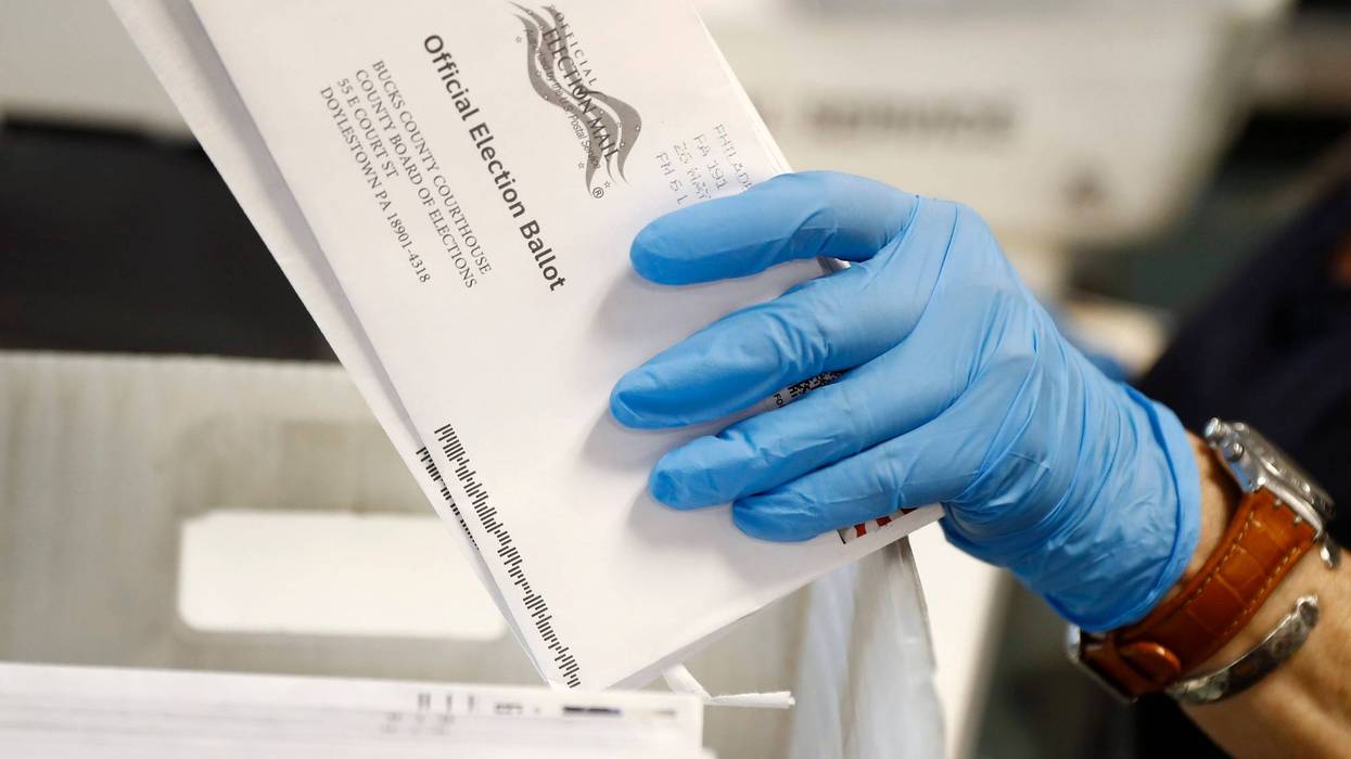 A worker processes mail-in ballots at the Bucks County Board of Elections office prior to the primary election in Doylestown, Pa., May 27, 2020.