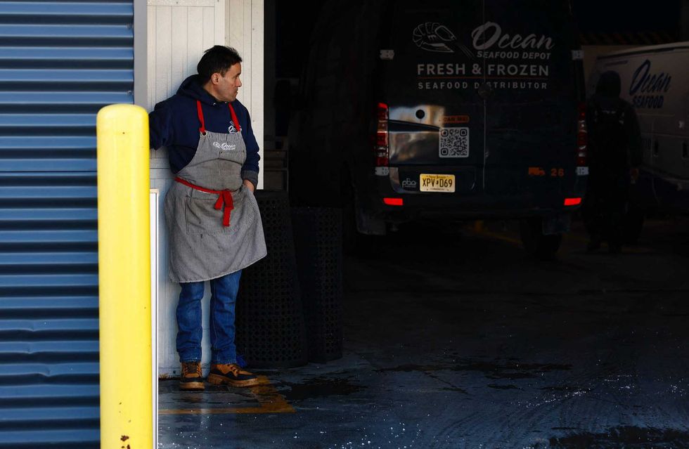 A worker stands at the parking area of the Ocean Seafood Depot where several workers were arrested on Jan. 23, 2025, by Immigration and Customs Enforcement (ICE) officers, in Newark New Jersey, on Jan. 24, 2025.