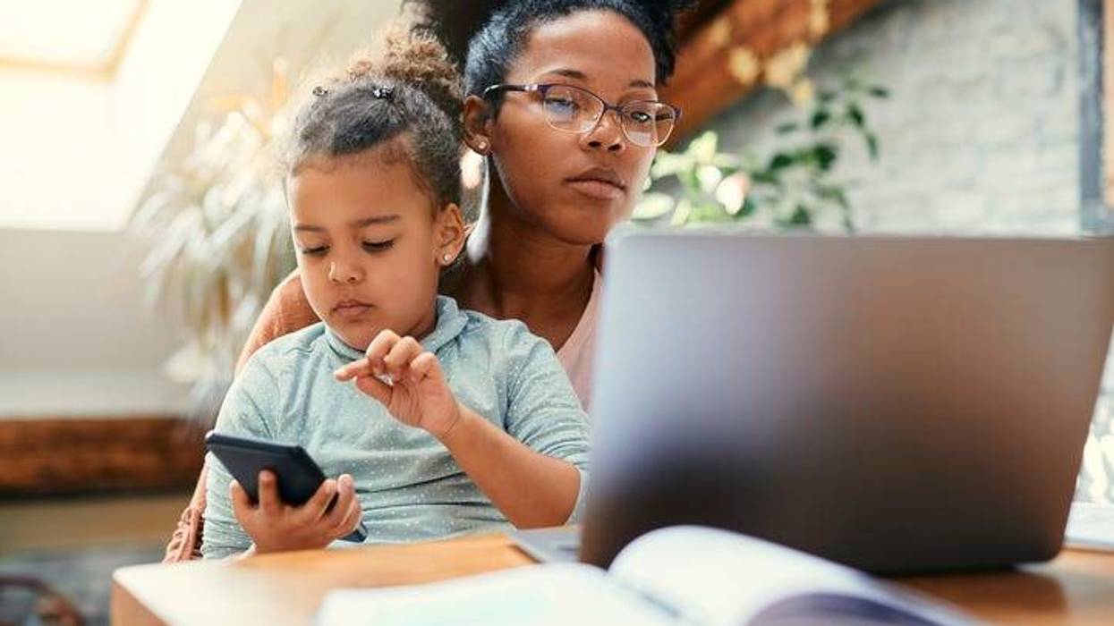 a working mom with her child and a laptop at home