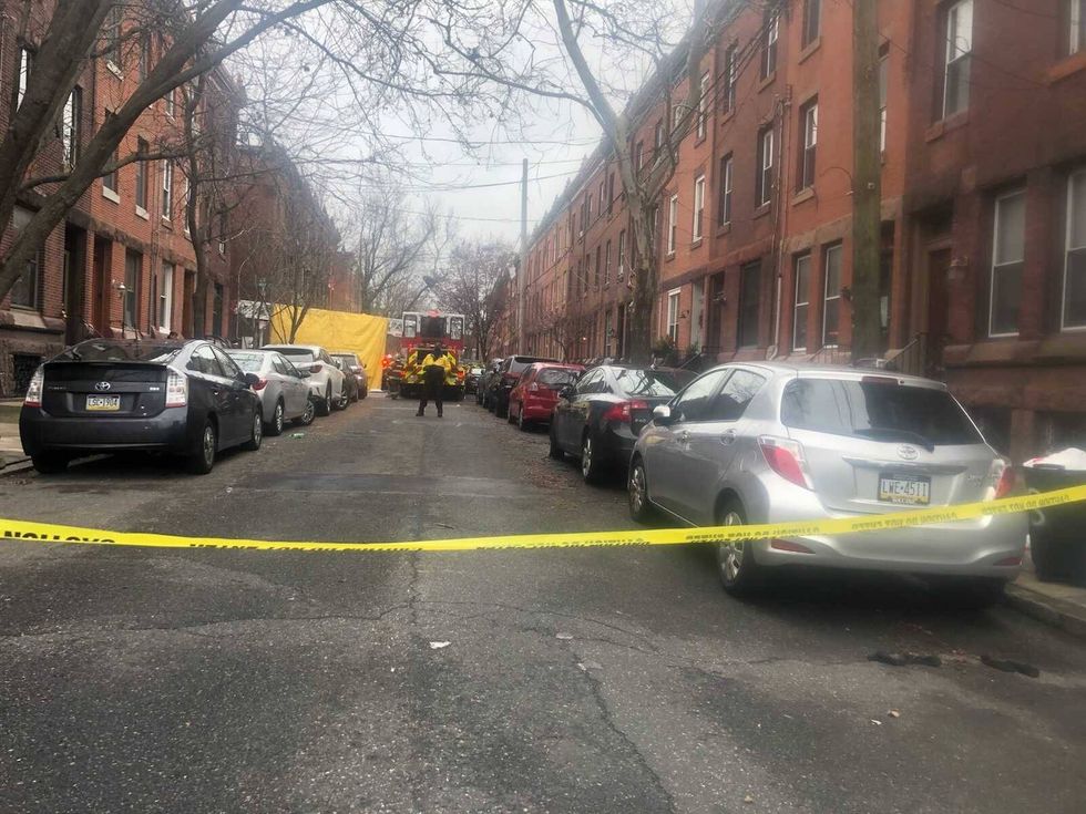 A yellow tarp placed outside the location of a fire that killed 13 people in Philadelphia