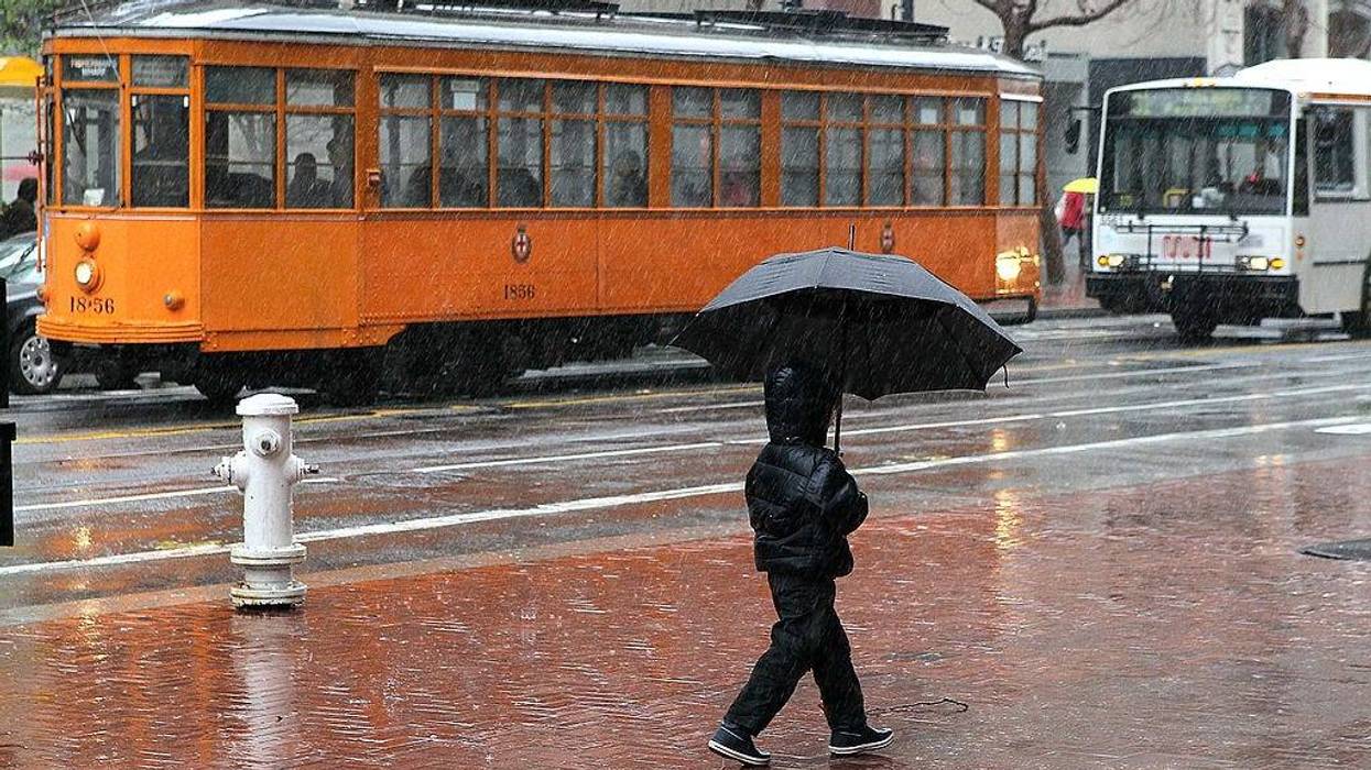 A young boy carries an umbrella as he walks down Market Street on February 17, 2011 in San Francisco, California.