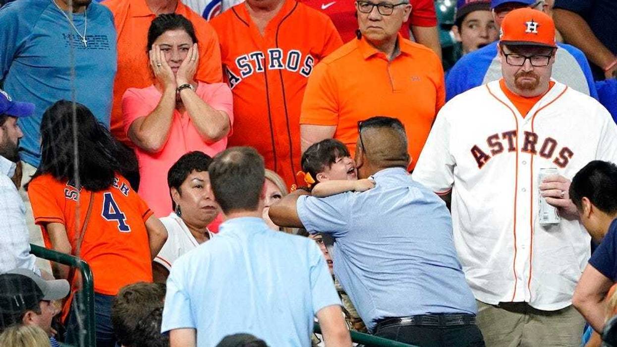 a young child is carried from the stands after being injured by a foul ball off the bat of Chicago Cubs' Albert Almora Jr.