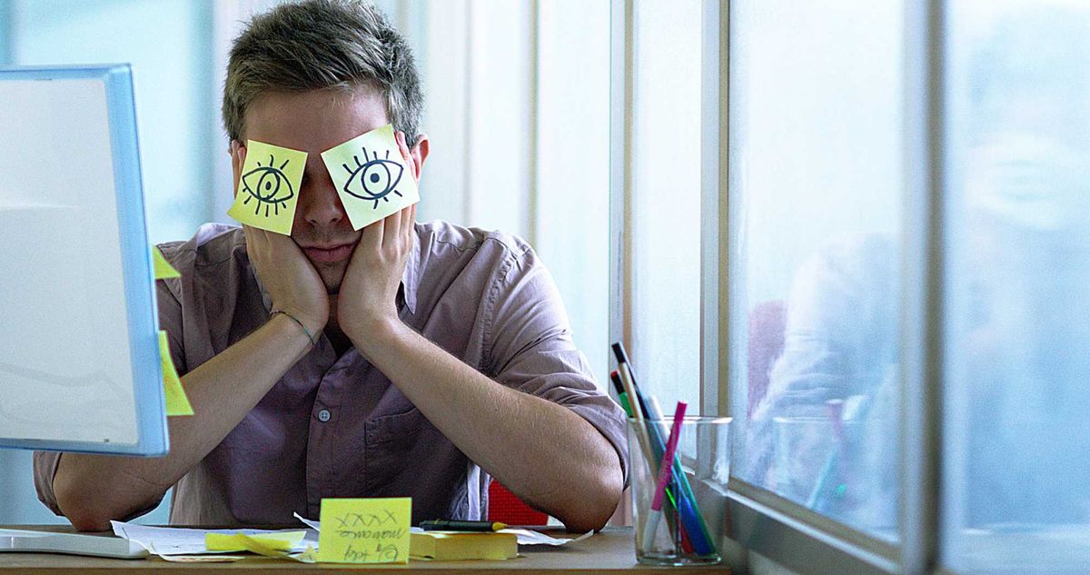 A young employee sleeps in his office.