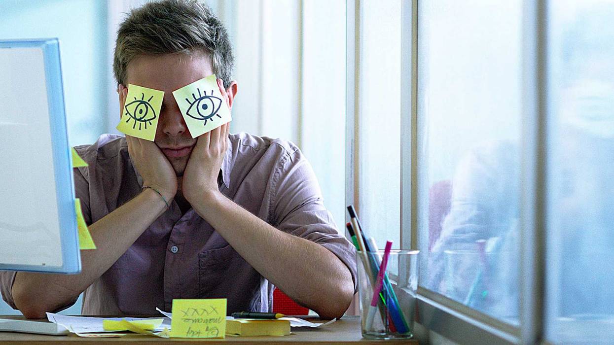 A young employee sleeps in his office.
