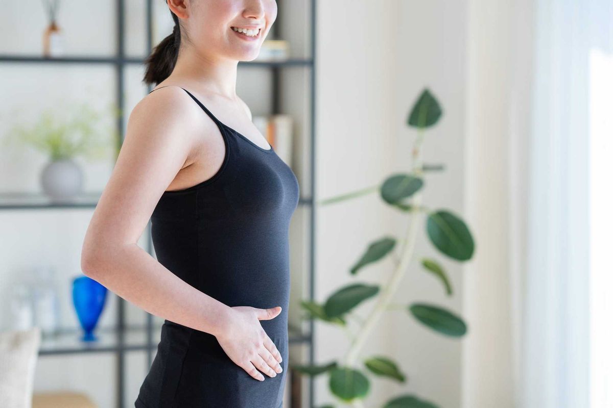 A young Japanese woman concerned about her stomach