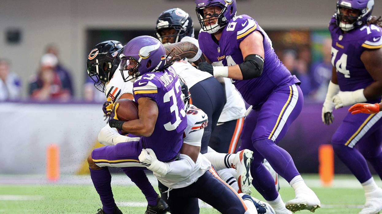 Aaron Jones #33 of the Minnesota Vikings is tackled by Dominique Robinson #90 of the Chicago Bears during the first quarter at U.S. Bank Stadium on November 16, 2025 in Minneapolis, Minnesota.