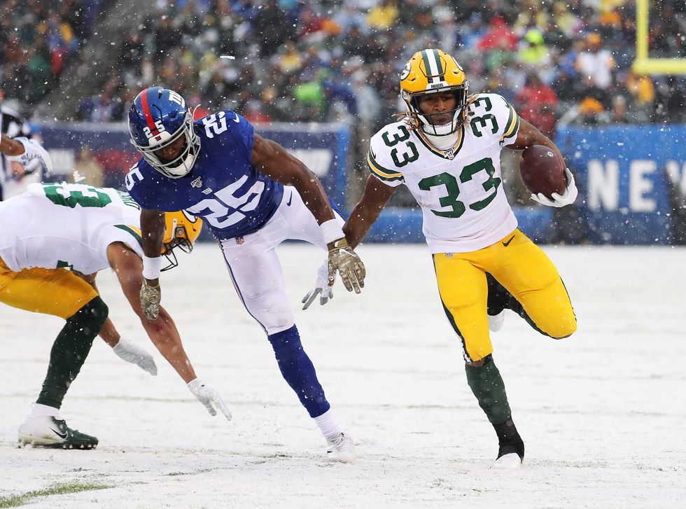 Aaron Jones tries to elude a Giants defender rushing to the outside