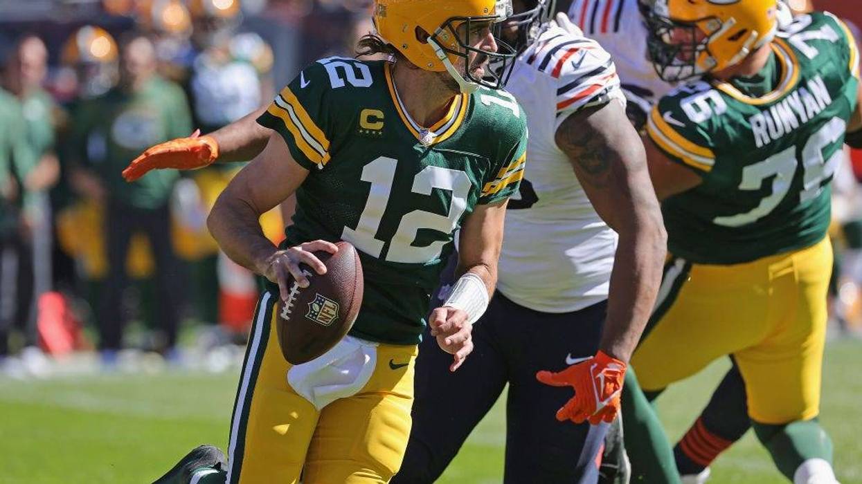 Aaron Rodgers #12 of the Green Bay Packers is chased by Akiem Hicks #96 of the Chicago Bears at Soldier Field on October 17, 2021 in Chicago, Illinois. The Packers defeated the Bears 24-14.