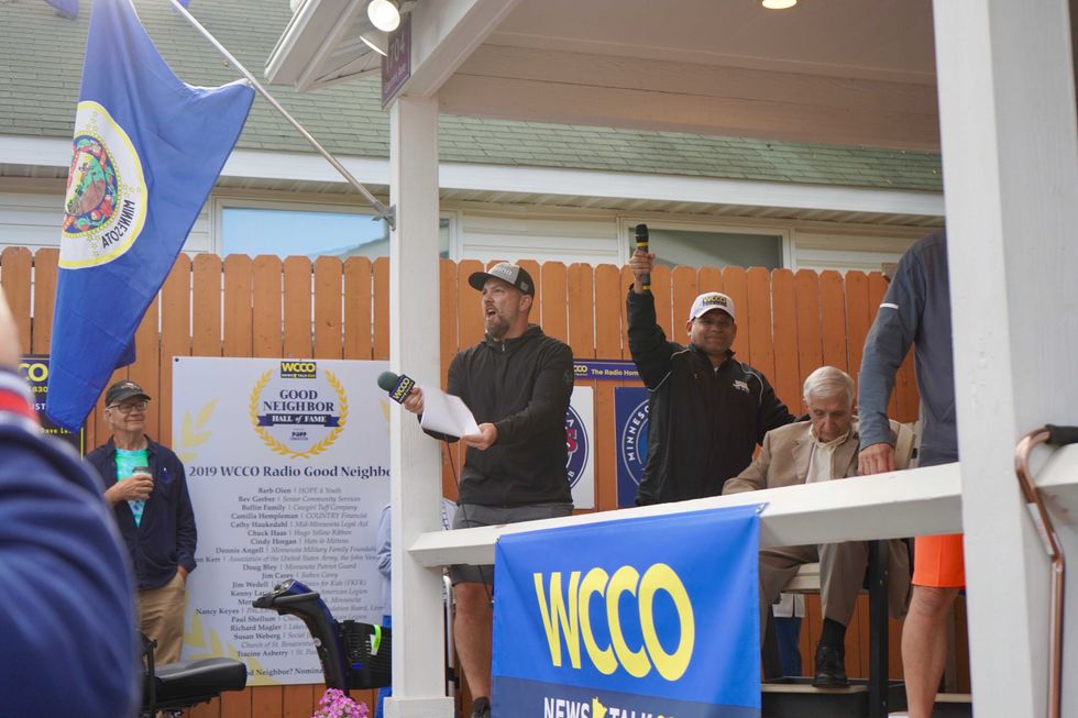 Adam Carter turns the microphone to the crowd while broadcasting from News Talk 830 WCCO