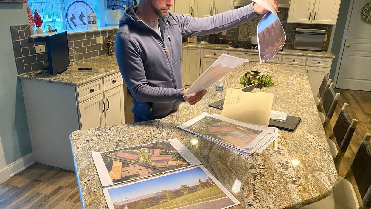 Adam Pennypacker looks at printed renderings of construction plans for a massive warehouse complex