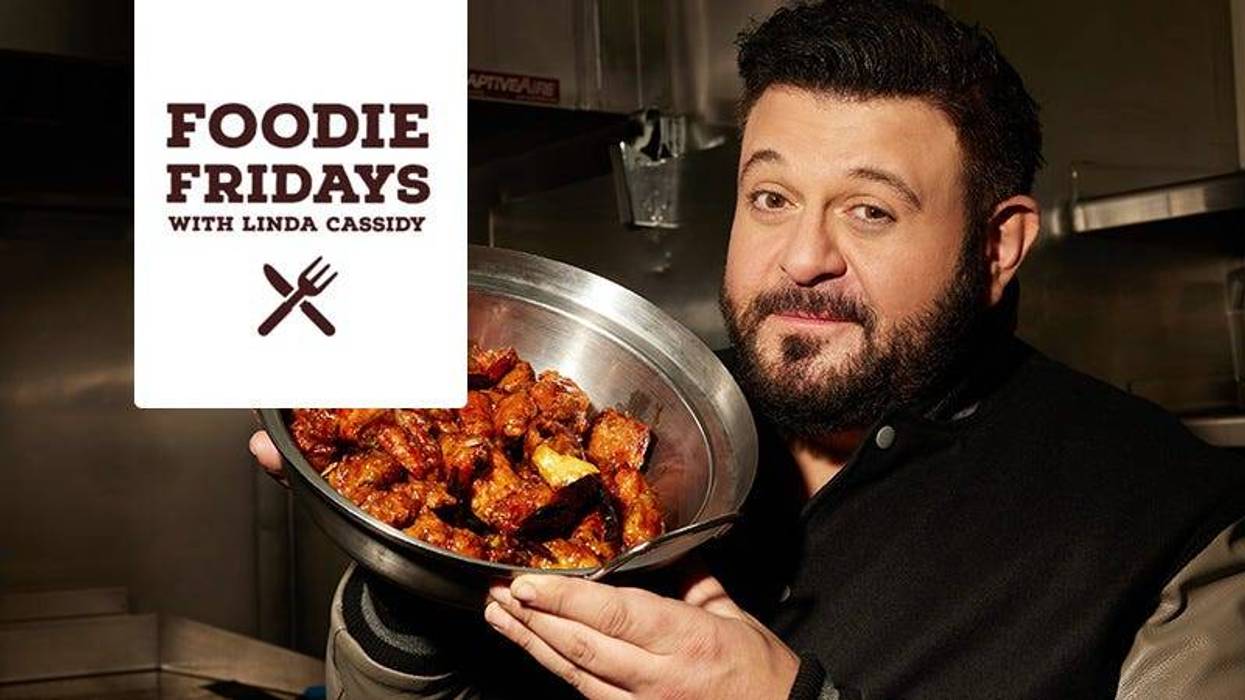 Adam Richman holding bowl of chicken wings