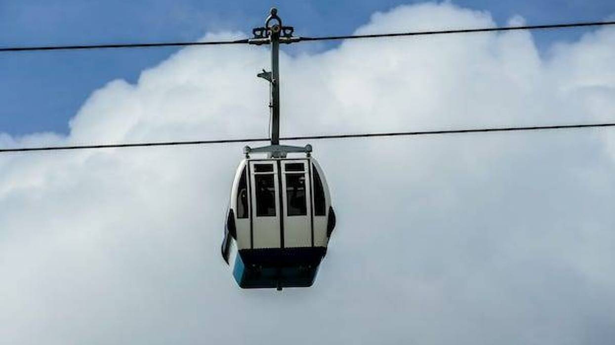 Aerial cable car against blue sky, white clouds