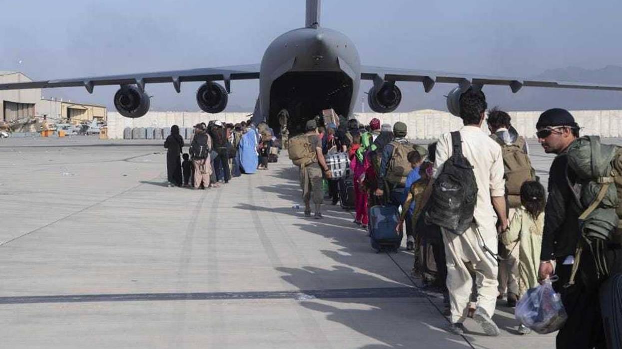 Afghanis board a plane to leave the Taliban-ruled country