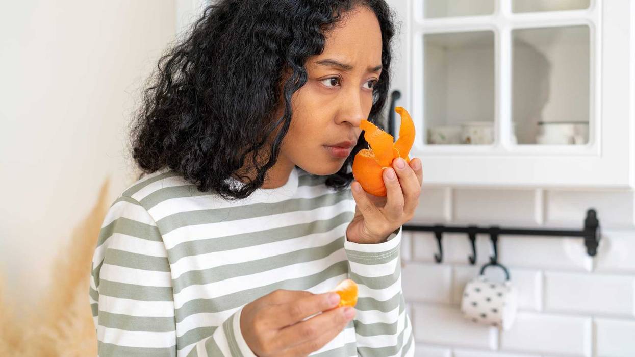 African-american woman suffering from long-term effects after having coronavirus. Concept of loosing sense of smell due to covid19. Female has anosmia disease. Lack of fruit flavor and aroma
