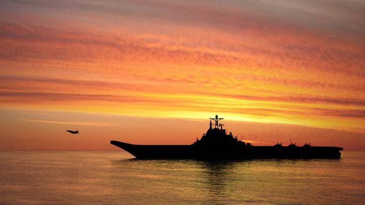 Aircraft carrier at sunset.