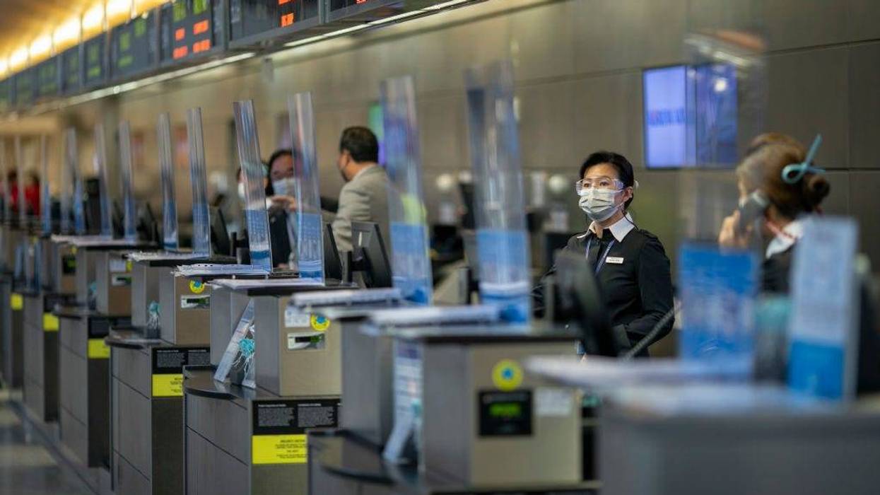 Airline employees wait for customers at a nearly empty LAX Tom Bradley International Terminal on Thanksgiving eve