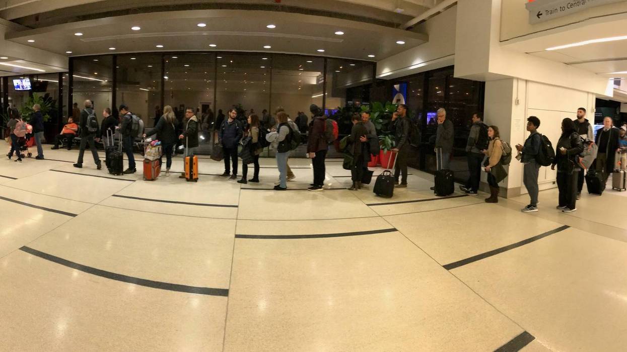 Airport passengers wait to go through a TSA security checkpoint early Wednesday morning at Philadelphia International Airport.
