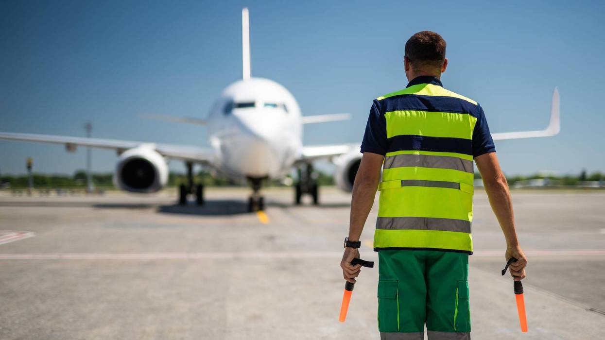 airport worker meeting passenger aircraft