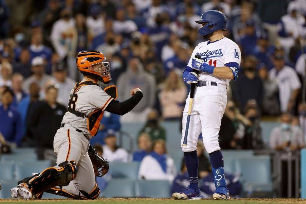 AJ Pollock #11 of the Los Angeles Dodgers reacts after striking out in front of Buster Posey #28 of the San Francisco Giants during the ninth inning in game 3.
