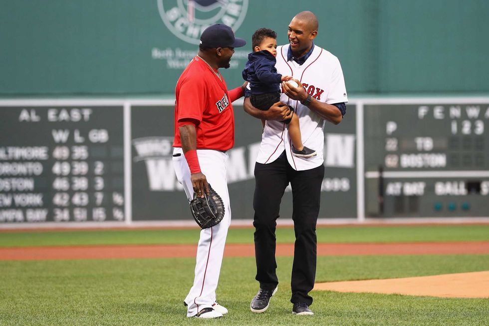 Al Horford of the Boston Celtics, holding his son Ean, talks with David Ortiz #34 of the Boston Red Sox after throwing out the first pitch before the game between the Boston Red Sox and the Tampa Bay Rays at Fenway Park on July 8, 2016 in Boston, Massachusetts.