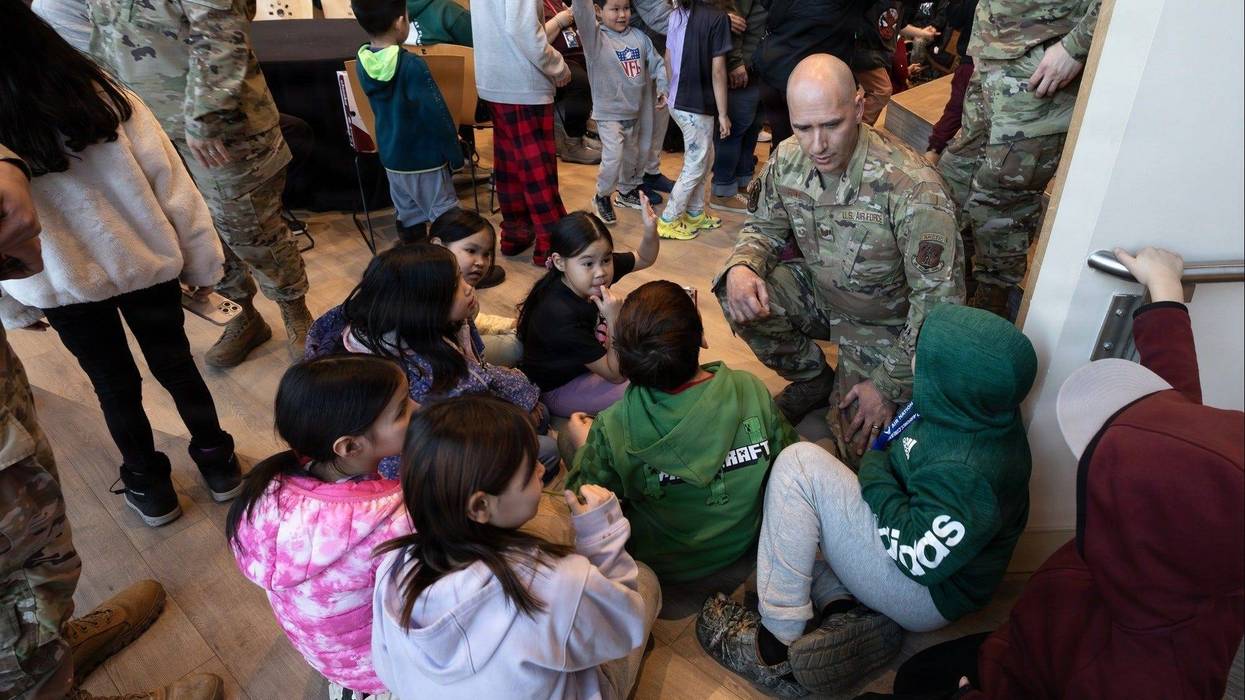 Alaska Air National Guard Tech. Sgt. Jonathan Goins, an aircraft metals technician assigned to the 176th Wing, interacts with children from Kipnuk and Kwigillingok during Operation Santa Claus 2025 at the Alaska Native Heritage Center in Anchorage, Alaska, on Dec. 14, 2025.