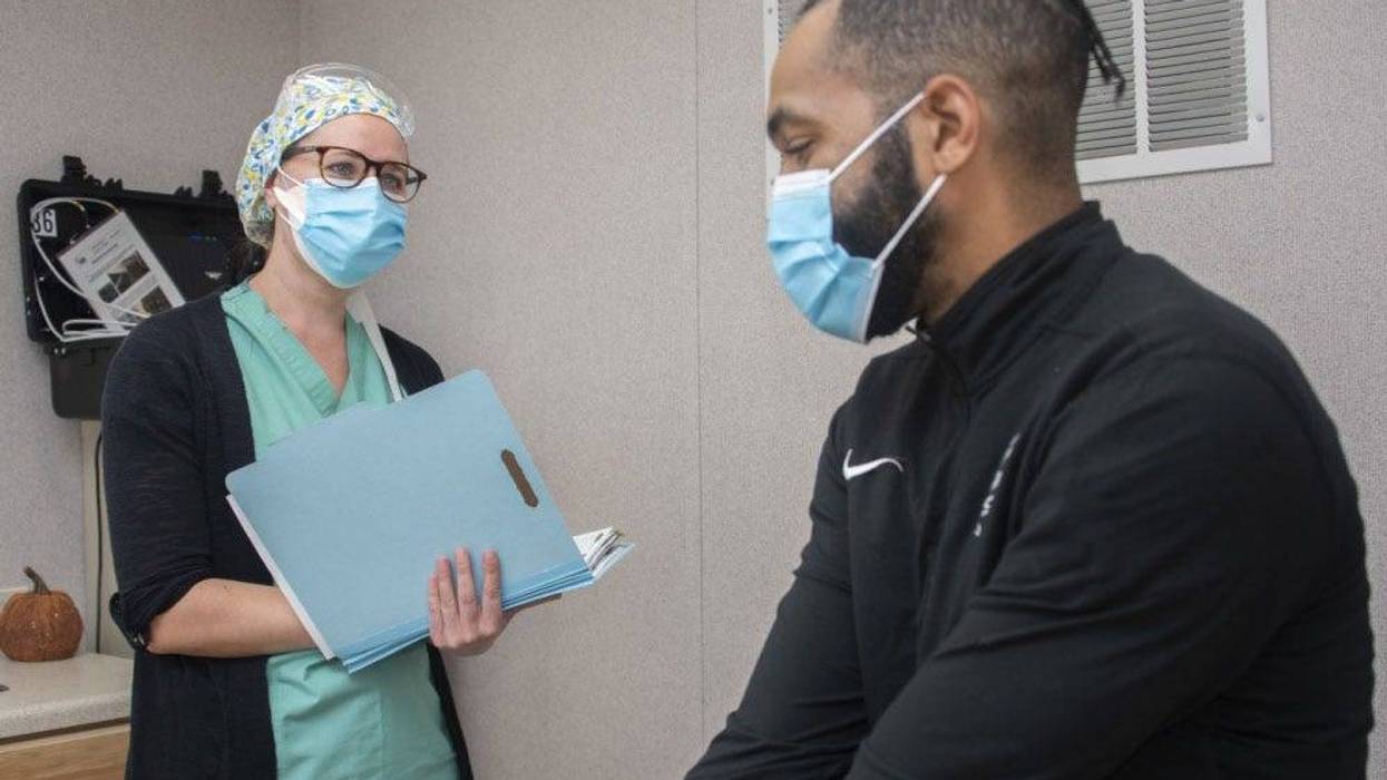 Alfiya Mityukova, a registered nurse, and Roderick Johnson, a research assistant, demonstrate patient screening for the Operation Warp Speed COVID-19 vaccine trial at Brooke Army Medical Center, Fort Sam Houston, Texas, Nov. 16, 2020.