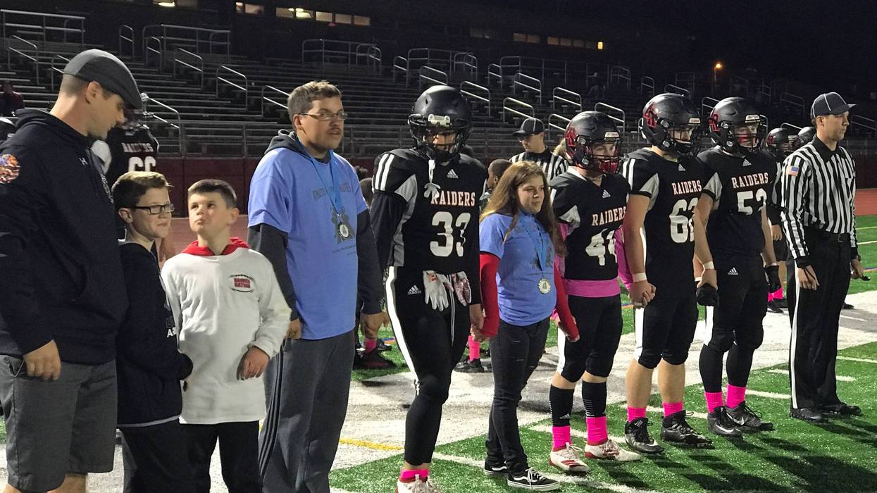 Alivia Sciarra standing alongside members of the Archbishop Ryan High School football team. Sciarra, who has special needs, got to be an honorary captain, and was named honorary homecoming queen as well.
